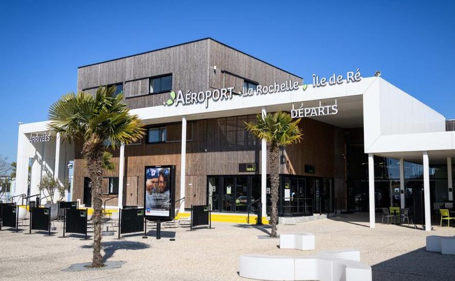 a large building with palm trees in front of it at LoveroomL1TIMISTE TAR in La Rochelle