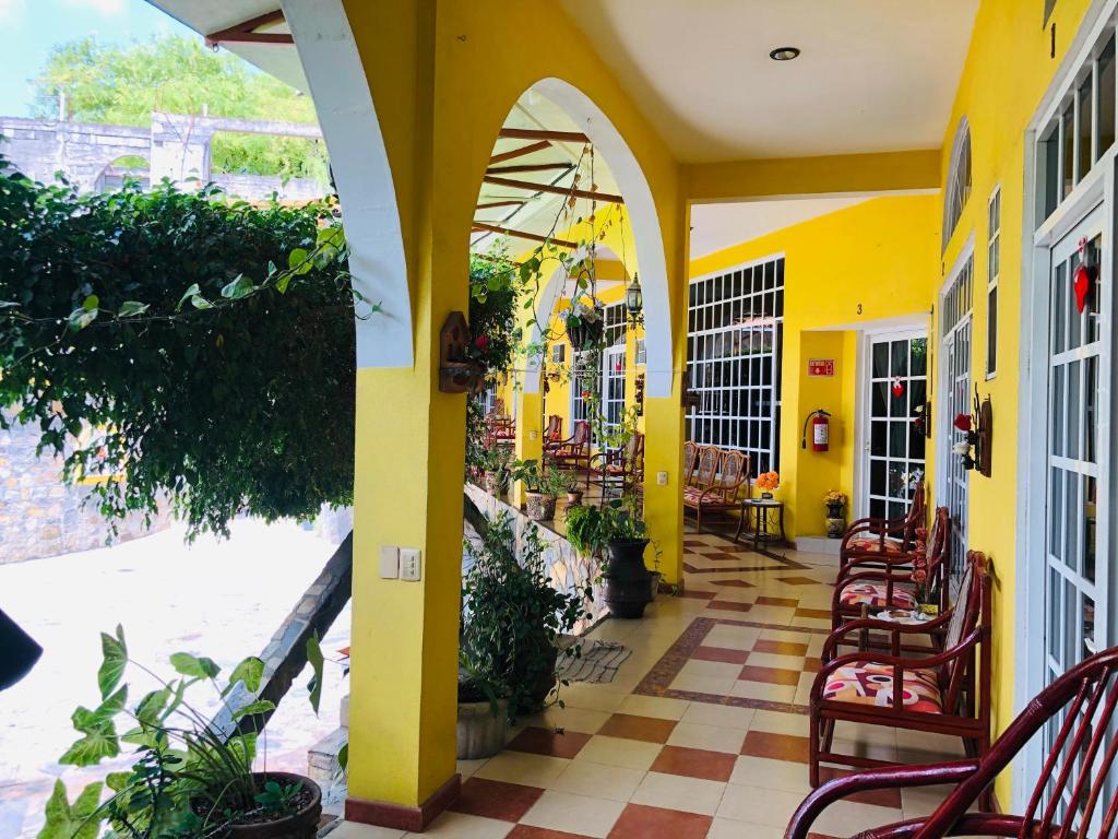 ein Restaurant mit gelben Wänden, Tischen und Stühlen in der Unterkunft Hotel Magic Collinn in Cedro