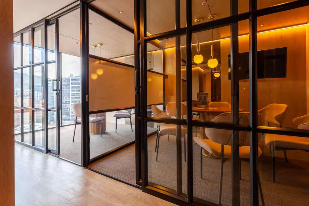 a room with glass doors and a dining room at UniqueMine Apartamento Deluxe in Bogotá