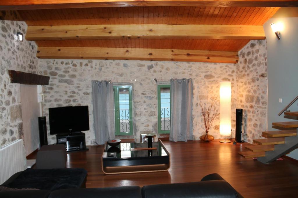 a living room with a couch and a tv at Coeur de Vogüé in Vogüé