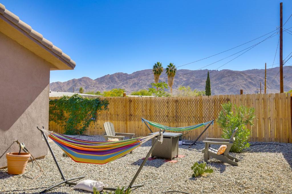 two hammocks and chairs in a backyard with a fence at Family Home, 7 Mi to Joshua Tree National Park! in Twentynine Palms