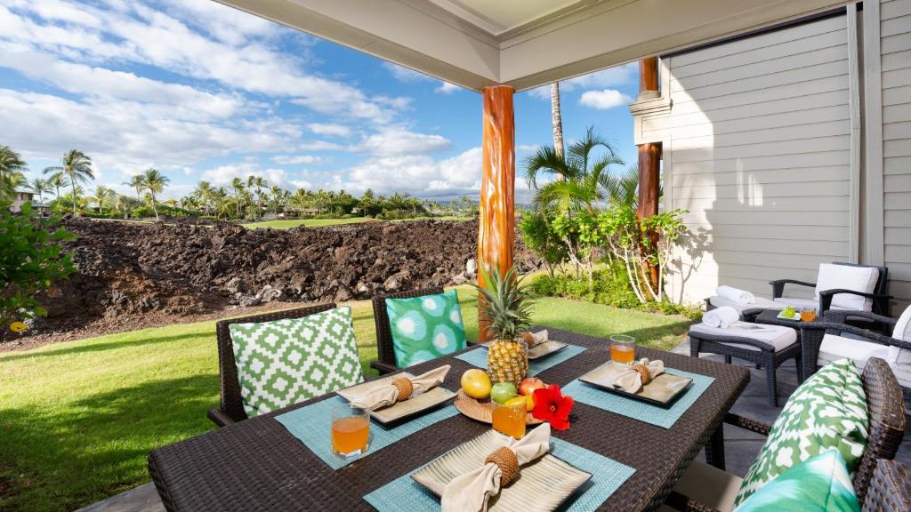 d'une terrasse avec une table et des chaises offrant une vue sur l'océan. dans l'établissement HAWAII BLUE VILLA Charming 3BR Golf Villas Home Close to Pool, à Waikoloa