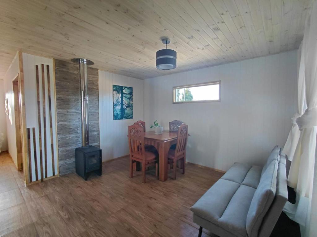 a living room with a table and a couch at Cabaña Aeropuerto el Tepual 3 in Puerto Montt