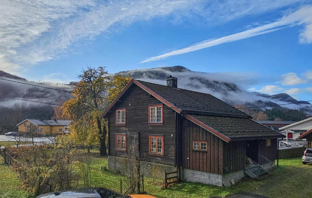a small wooden house in a field with mountains in the background at Beautiful Home In Dalen With Harbor View in Dalen