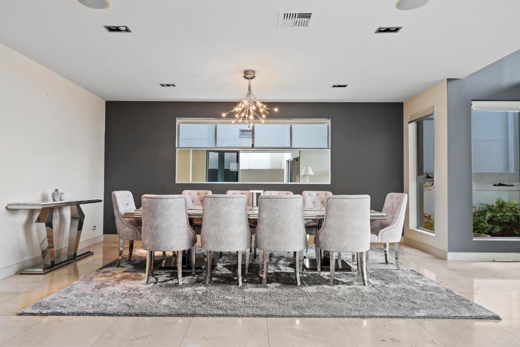 Un comedor con mesa y sillas en 3BR Riverfront Retreat with Office, Pool & Pontoon, en Gold Coast