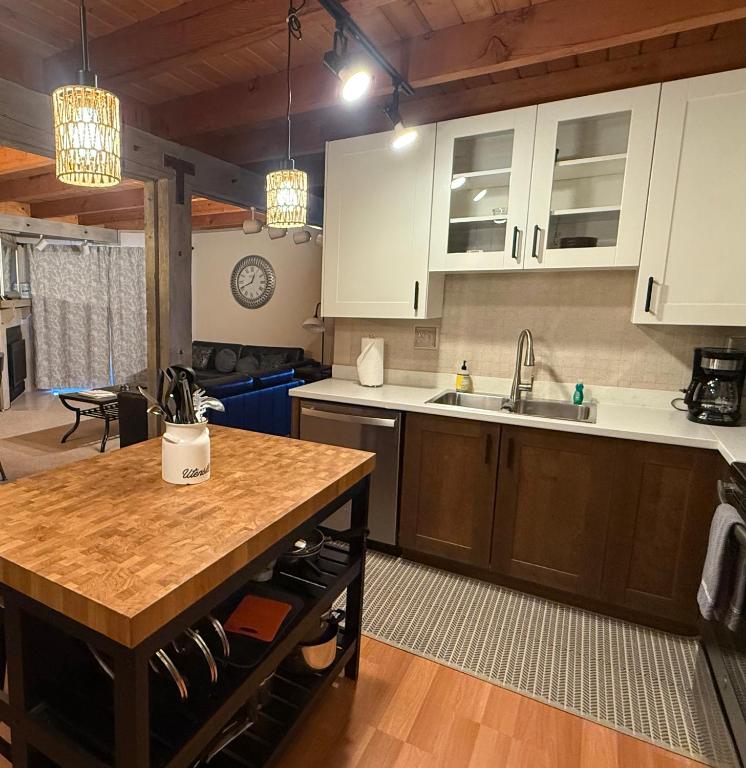 a kitchen with white cabinets and a wooden counter top at Summit County Wildernest Condo in Silverthorne