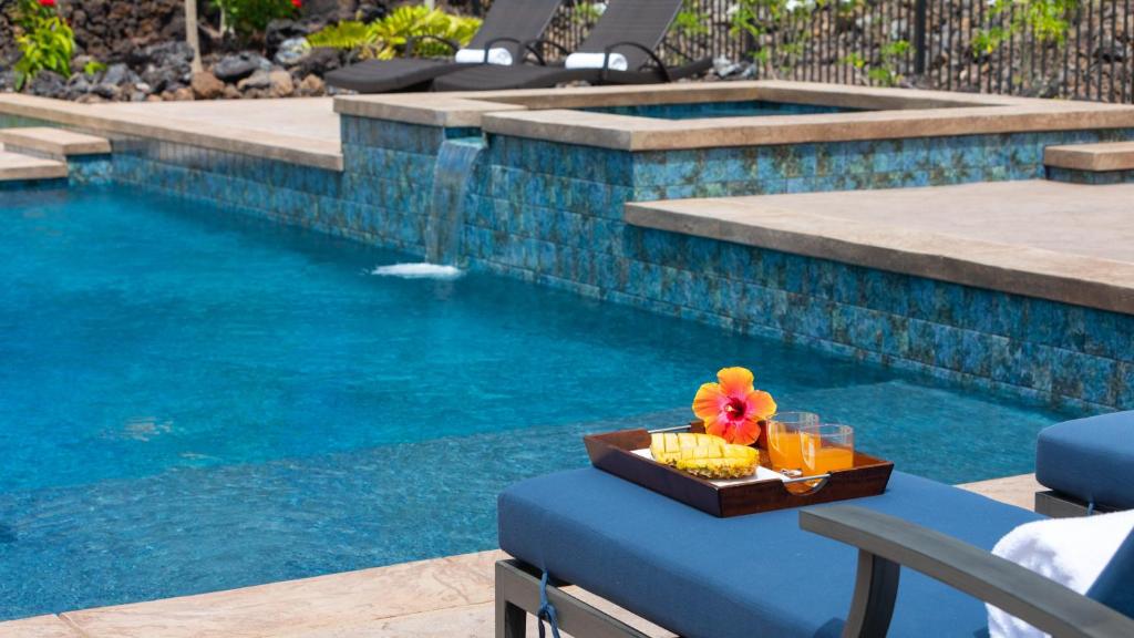 una bandeja de comida en una mesa junto a la piscina en ❤PiH❤Aloha Paradise Large Private Pool Waterfall Spa PLUS 2024 Resort Pool Passes, en Waikoloa