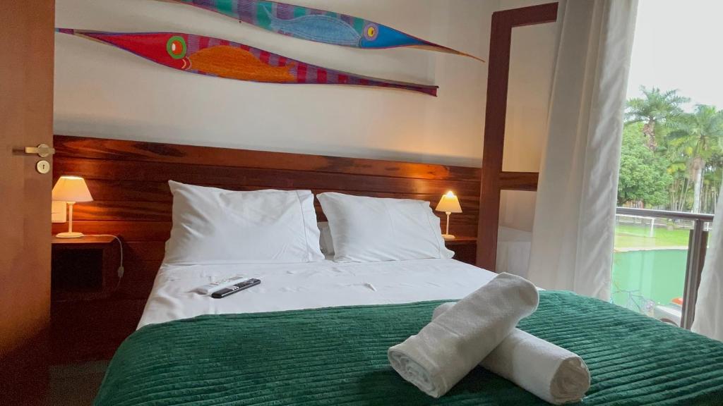 a bedroom with a bed with two towels on it at Casa Vista Verde in Paraty