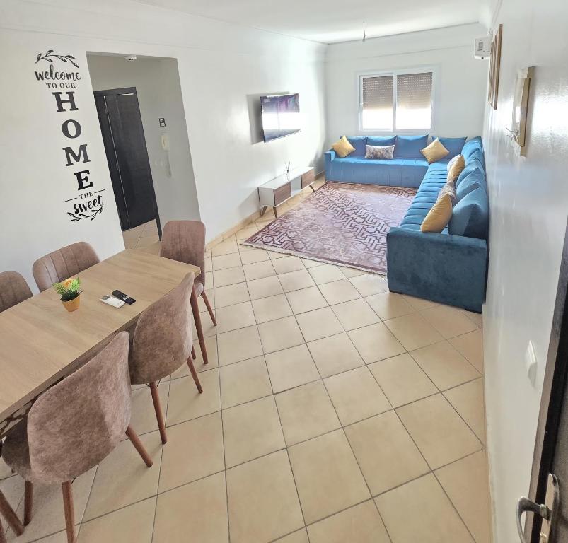 un salon avec un canapé bleu et une table dans l'établissement Appartement freedom, à Agadir