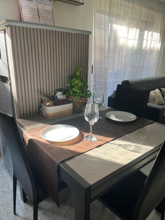 a table with two plates and a wine glass on it at Alloggio Turistico in Via Zotti in Lido di Ostia