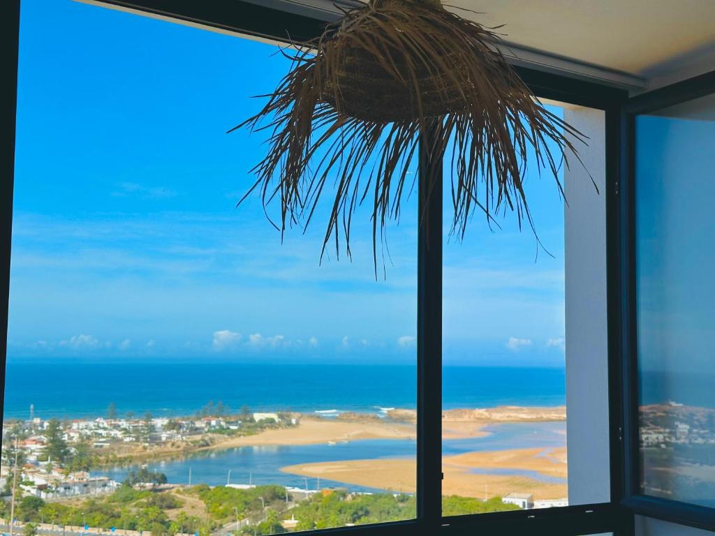 a view of the beach from a room with a window at Appartement La Plage Vue sur Mer pour les familles in Oualidia