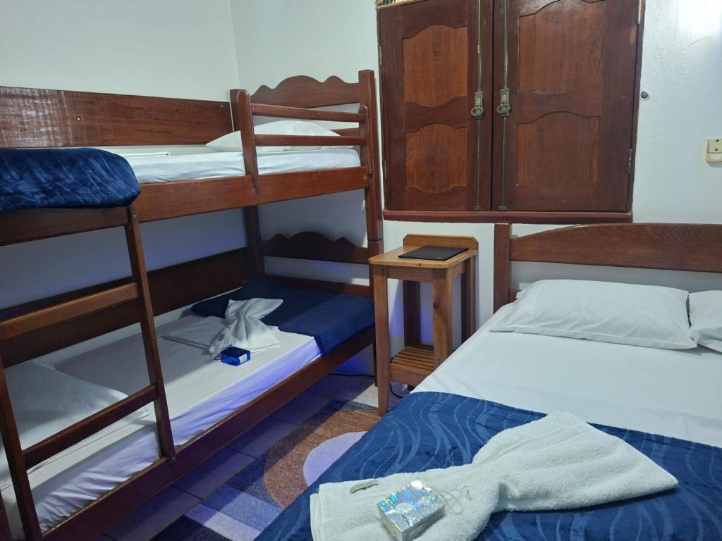 a room with two bunk beds and a table at Suite aconchegante do Tapana in Belém