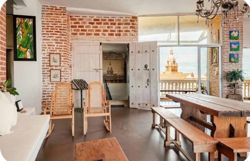 une salle à manger avec une table et un mur de briques dans l'établissement Apartamento en Cartagena en la Ciudad Amurallada, à Bogotá