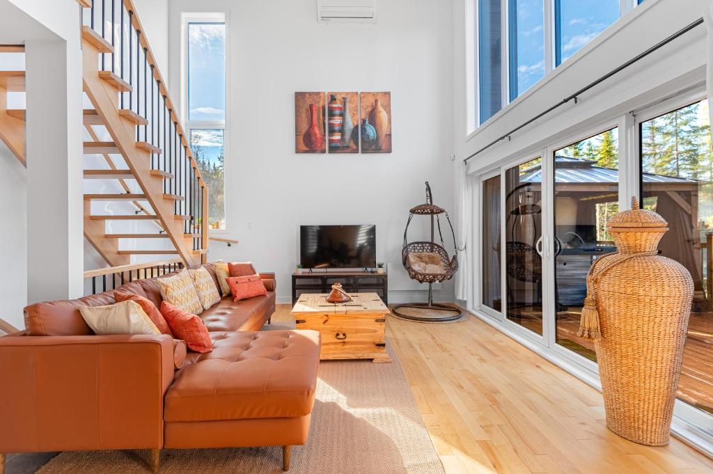 un salon avec un canapé et un escalier dans l'établissement Boho Vibes Cottage, à Sainte-Lucie-de-Doncaster