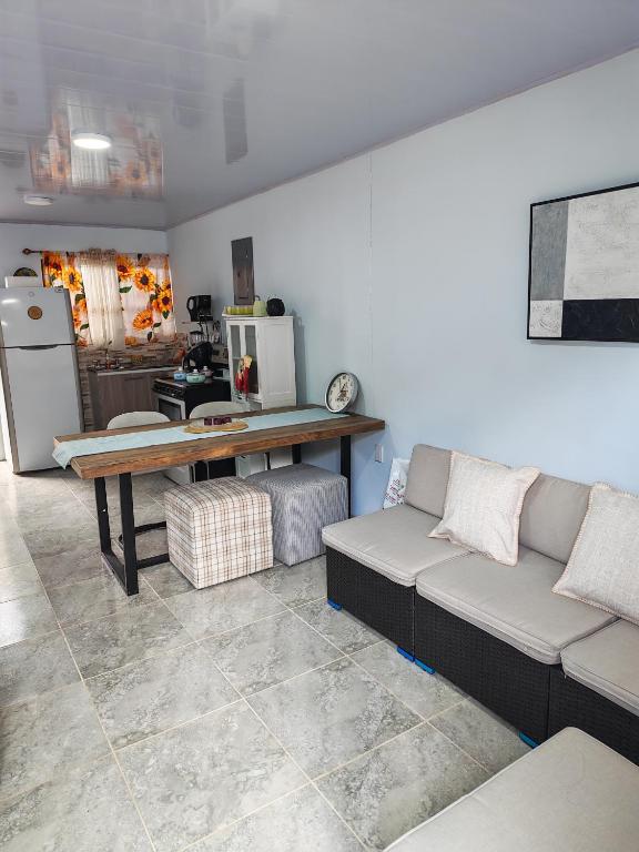 a living room with a couch and a table at Pequeña Casita Karina in Nicoya