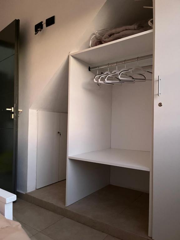 a walk in closet with white walls and white shelves at Orillas del Sol Triplex in Chascomús