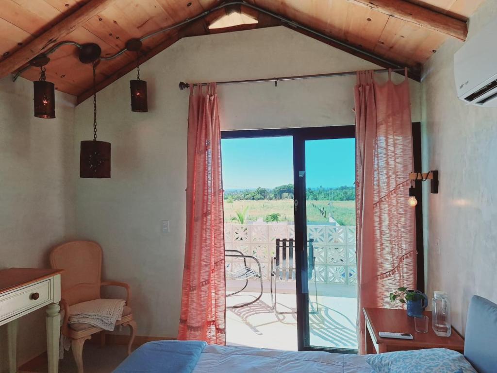 a bedroom with a window with a view of a patio at Casita Baja Beans Pink in El Pescadero