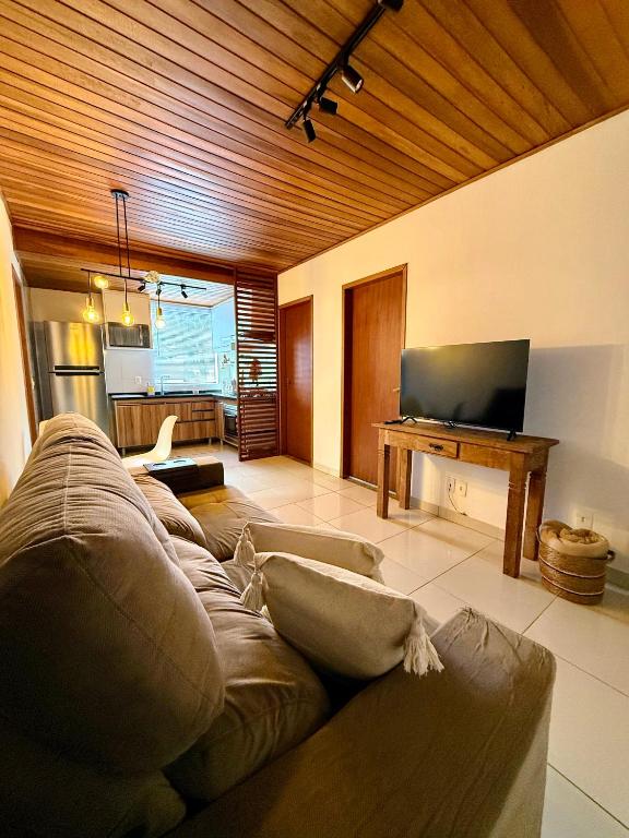 a living room with a couch and a flat screen tv at NaCasinha in Resende