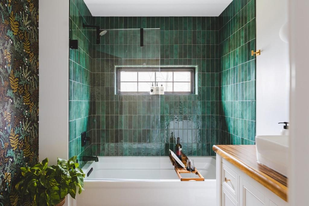 ein grün gefliestes Bad mit einer Badewanne und einem Waschbecken in der Unterkunft Paddle Point in West Milford