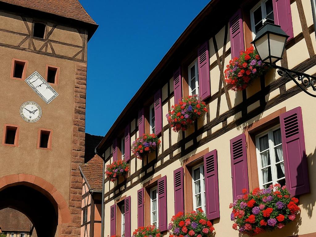 a building with flower boxes and a clock on it at Maison Alsacienne Historique avec Parking à Ammerschwihr - FR-1-744-23 in Ammerschwihr