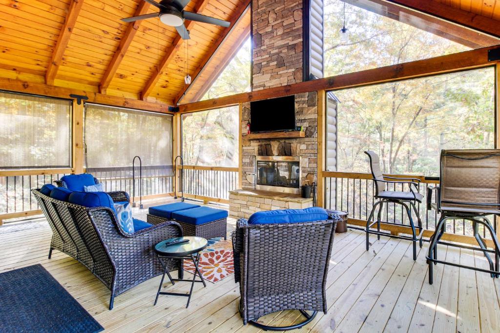 a screened in porch with furniture and a fireplace at Hot Tub and Creek View Cabin about 6 Mi to Ellijay! in Ellijay