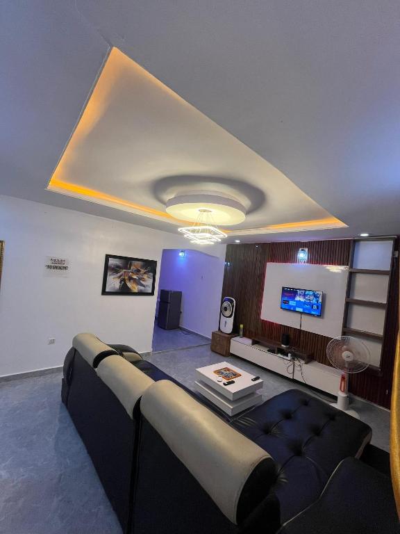 a living room with a couch and a flat screen tv at Cee&Tee at AKOBO 1Bedroom or 2Bedrooms -247 Electricity-Solar Inverter AC in Bedrooms in Ibadan