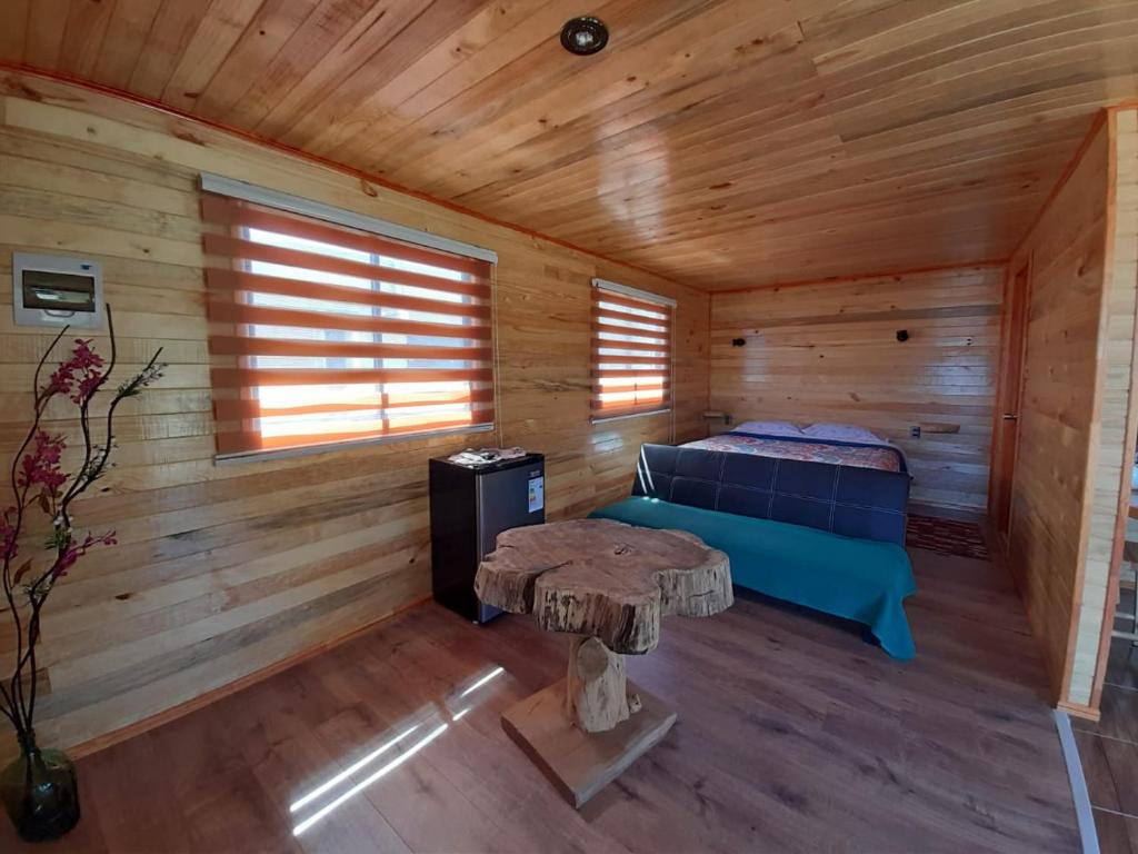 a log cabin with a bed and a table in it at Cabañas francisca in Valdivia