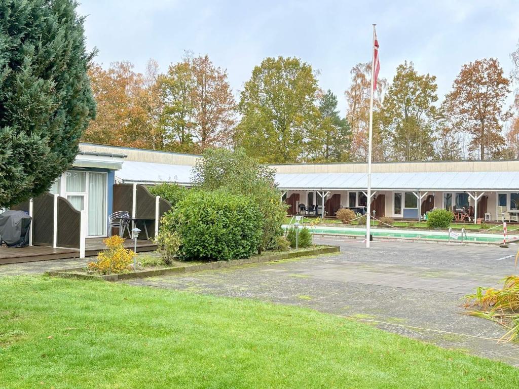 un bâtiment doté d'un drapeau devant lui dans l'établissement 4 person holiday home in Nexø, à Strandby Gårde