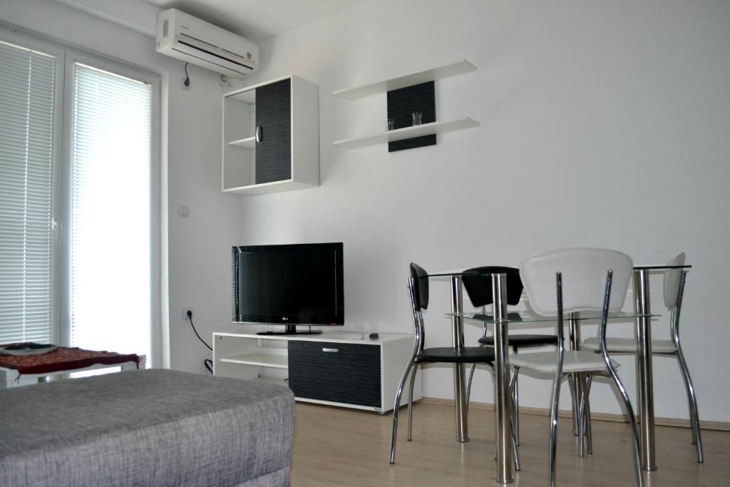 ein Schlafzimmer mit einem Tisch und Stühlen sowie einem TV in der Unterkunft Vila Roza in Star Dojran