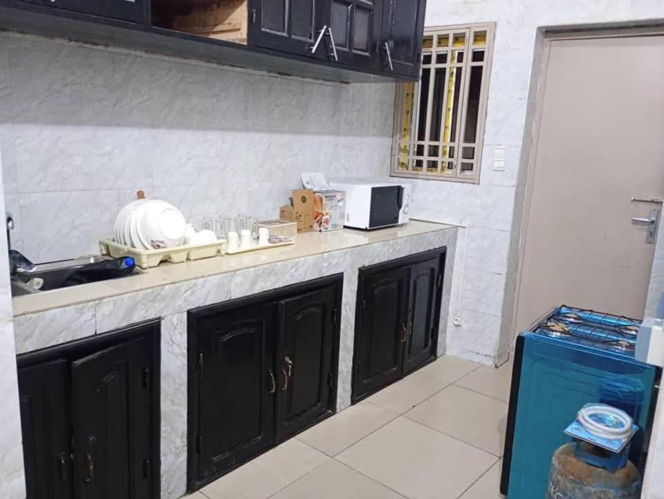 a kitchen with black cabinets and a counter top at Appartement au centre-ville in Brazzaville