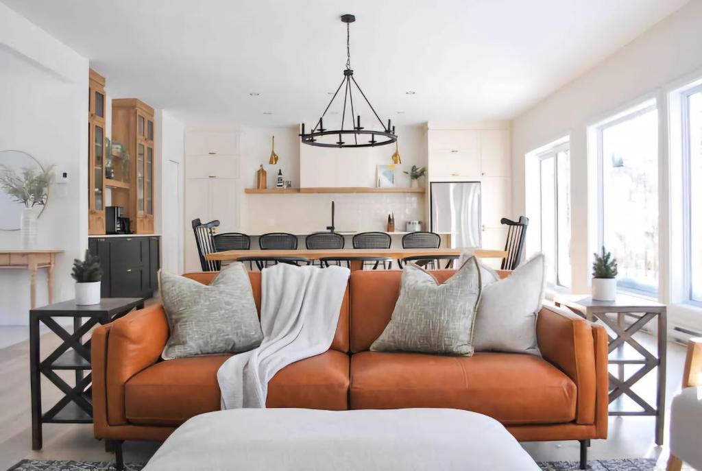 プティット・リヴィエール・サン・フランソワにあるChalet La Rocheuse et SPAのソファとキッチンのあるリビングルーム