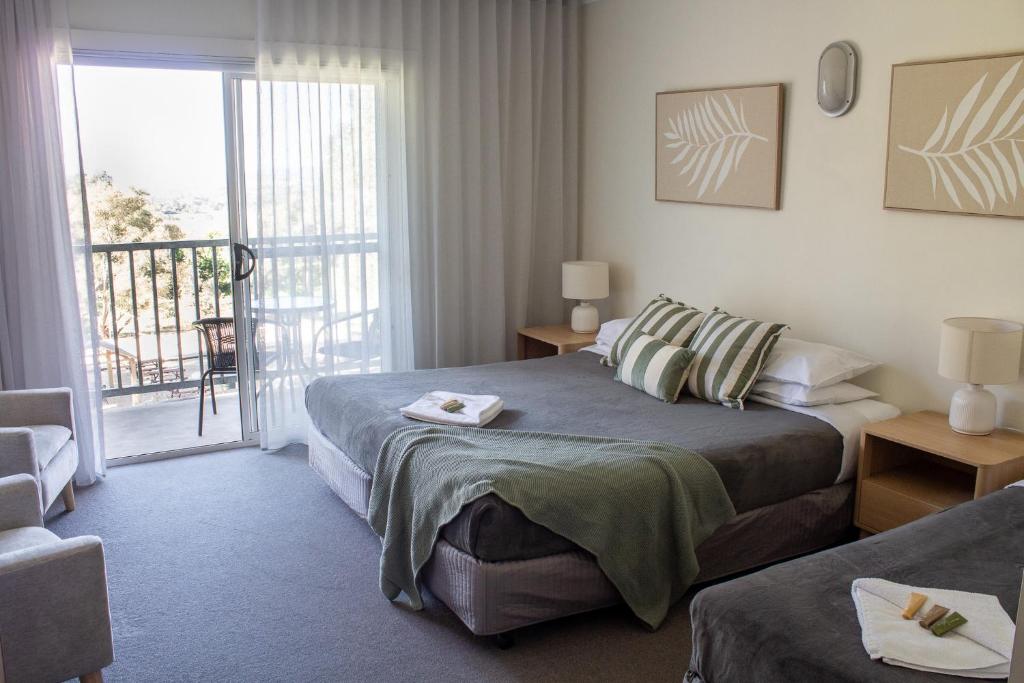 una habitación de hotel con una cama y un balcón en BATHURST GOLDFIELDS MOTEL at 428 CONROD STRAIGHT MOUNT PANORAMA, en Bathurst