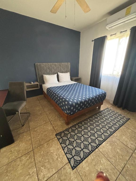 een slaapkamer met een bed, een stoel en een raam bij Habitacion Arboleda in Saltillo