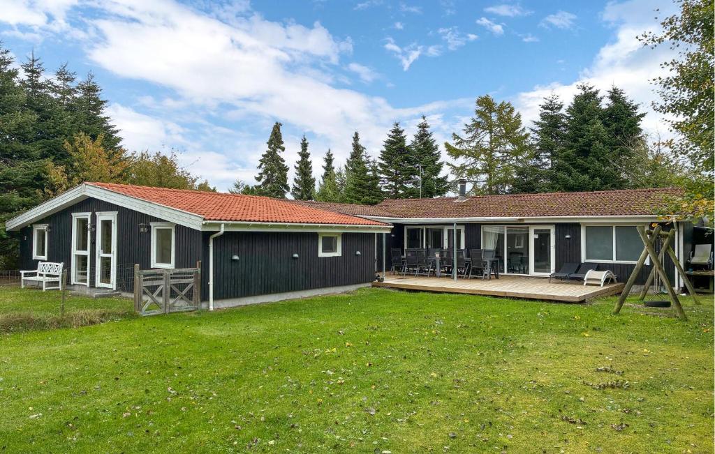 a house with a large yard in front of it at Awesome Home In Væggerløse With Sauna in Marielyst