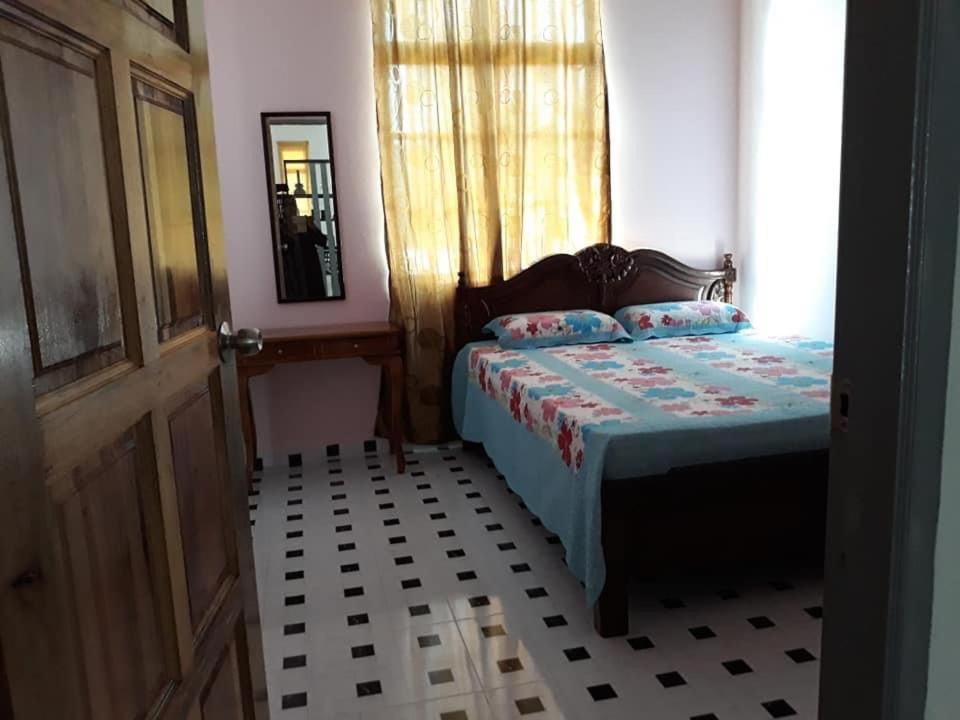 een slaapkamer met een bed, een spiegel en een deur bij Araz Homestsay in Kota Bharu