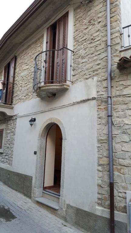 ein weißes Gebäude mit einem Balkon und einem Fenster in der Unterkunft Borgo Franza Case Vacanze in Basicò