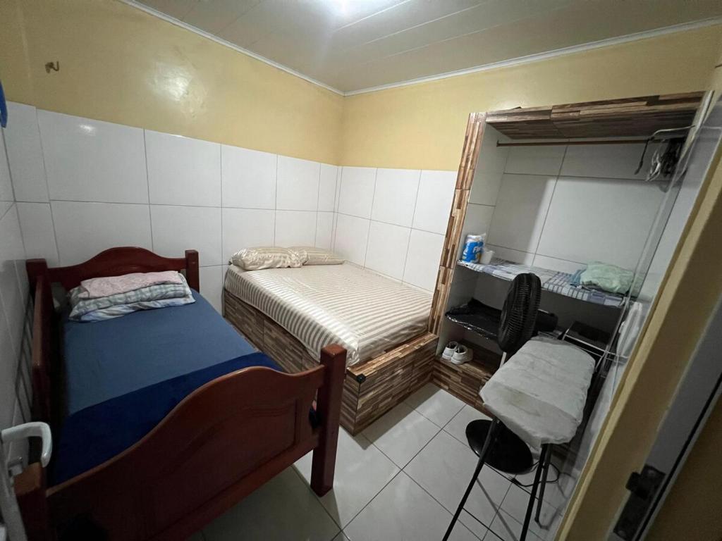 ein kleines Zimmer mit einem Bett und einem Spiegel in der Unterkunft Furnished Apartment Type House for COP30 in Belém