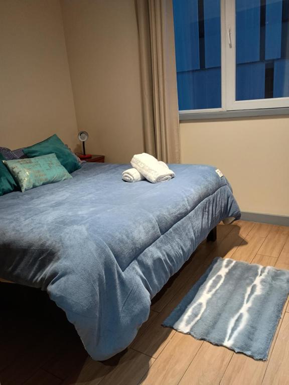 a bedroom with a bed with two towels on it at Departamento para Dos in Temuco