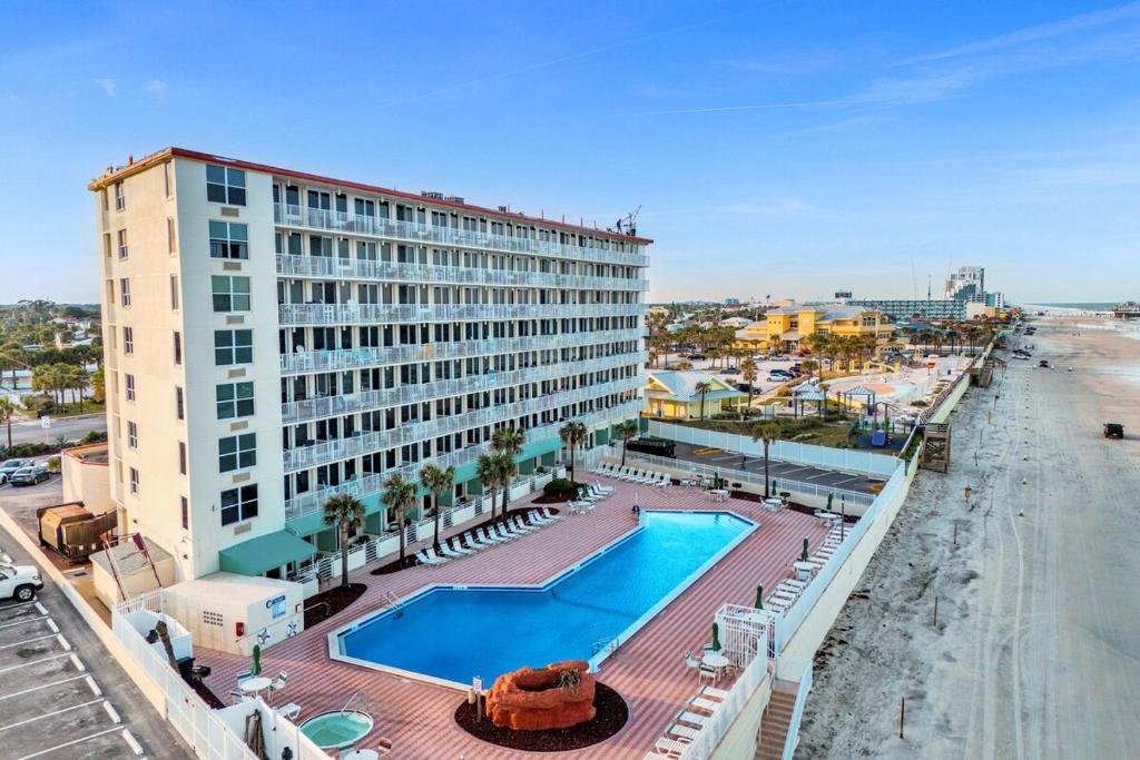 un hotel con piscina junto a una playa en Modern Beach Oasis - Sleeps 4 - Pool - Gym - Games, en Daytona Beach