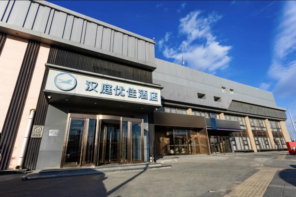 a building with a sign on the front of it at Hanting Premium Hotel Beijing Jiuxianqiao Chaoyang Station in Beijing