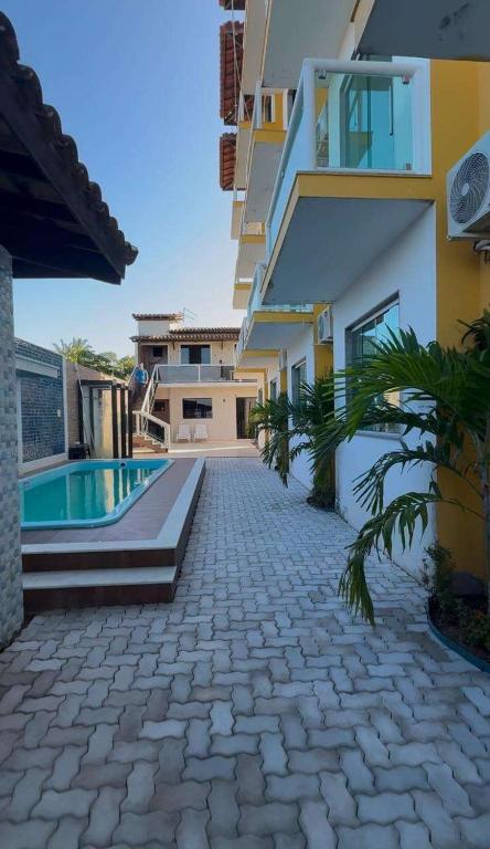 una casa con piscina al lado de un edificio en pousada tudo a ver, en Salinas da Margarida