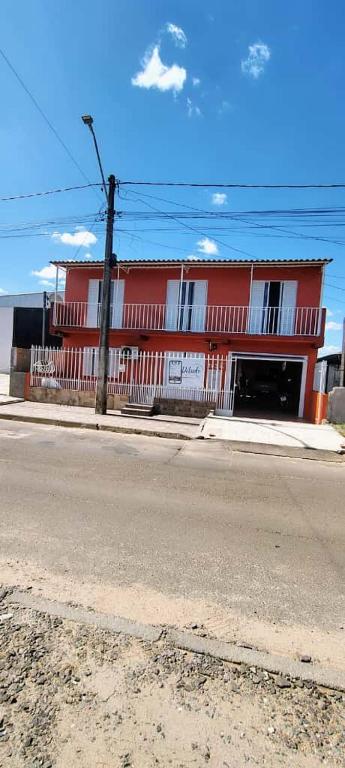 a red building on the side of a street at Pousada Aurora 3 in São Gabriel