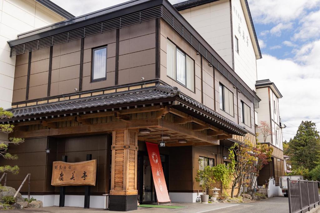 Un edificio con un cartel en el frente. en 割烹旅館 廣美亭, en Hanamaki