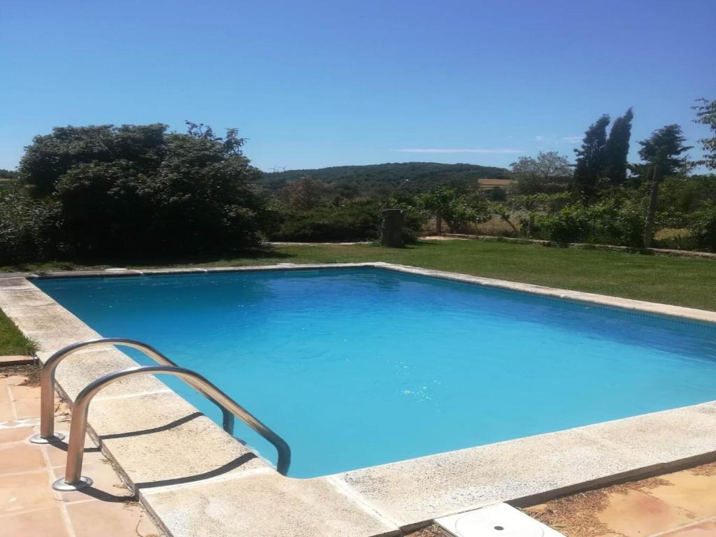a large blue swimming pool with a chair next to it at Detached rural 19th century country house in Calonge de Segarra