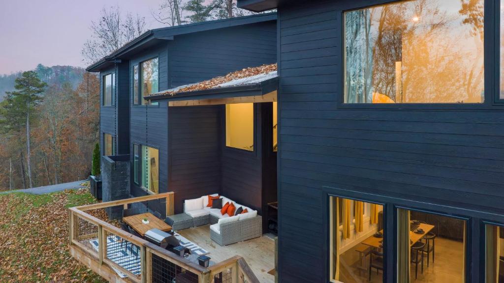 ein blaues Haus mit einer Veranda und einer Terrasse in der Unterkunft Dark Horse by AvantStay Secluded 5BDR w Hot Tub Game Room Deck Forest Views in Sevierville