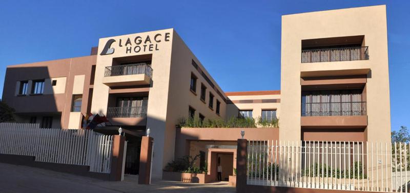 un grand bâtiment avec une clôture devant lui dans l'établissement Lagace Hotel, à Jounieh