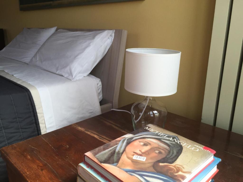 una lámpara en una mesa junto a una cama en B&B Treviglio en Treviglio