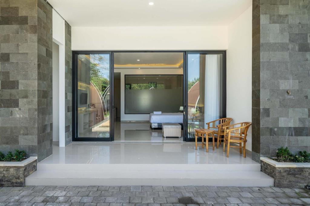 a house with glass doors and a table and chairs at Twin Room with Kitchen & Pool in Uluwatu - No 4 in Bingin Beach