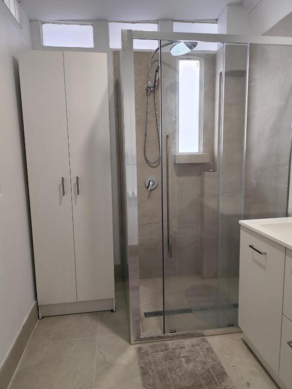 a shower with a glass door in a bathroom at Kaivalya Niketan in Perth