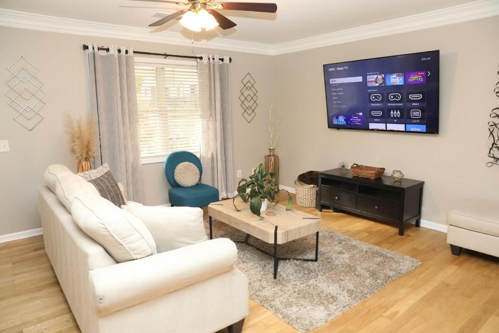 een woonkamer met een witte bank en een tv bij Family Fun Vibe in Marietta